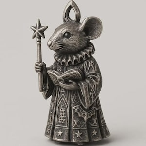 Può includere: Statuetta di topo color argento, vestita con una veste medievale e colletto a balze, che tiene in mano una bacchetta a stella e un libro aperto. Il topo ha grandi orecchie e un anello in alto per appenderlo. La veste è decorata con stelle e motivi gotici.