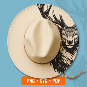 May include: A cream-coloured wide-brimmed hat featuring a black ink-style illustration of a deer head with large antlers on the right side of the brim. The hat has a brown band and a thin cord. An orange rectangular label displays the text PNG SVG PDF.