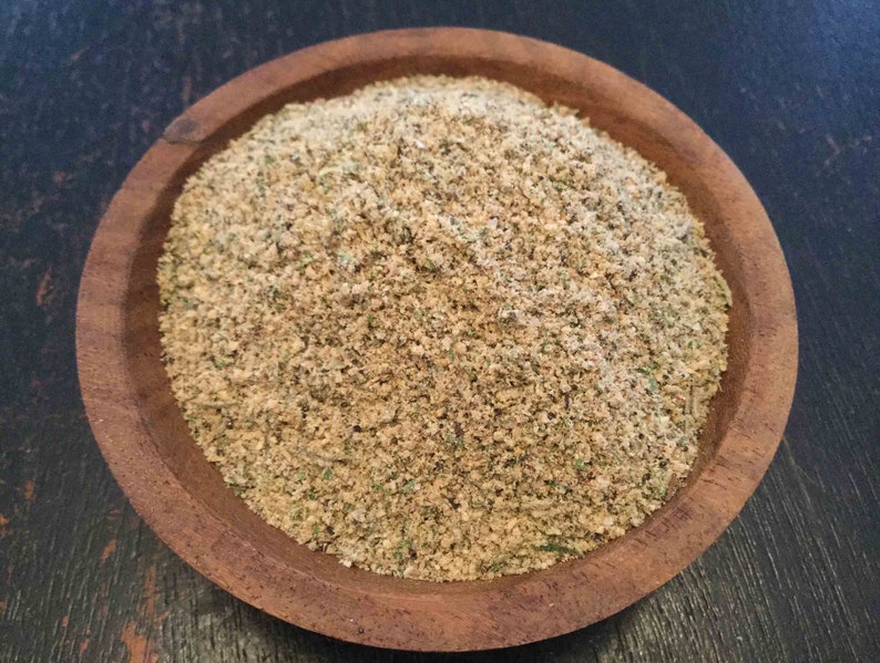 Puede incluir: Un cuenco de madera lleno de una mezcla de especias de color marr&oacute;n claro. La mezcla de especias parece ser una mezcla de hierbas y especias.