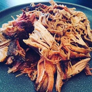 May include: A close-up of a plate of shredded pork, with a light brown color and a slightly crispy texture.