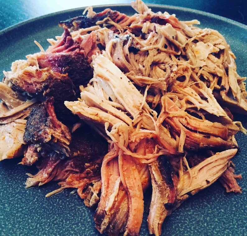 May include: A close-up of a plate of shredded pork, with a light brown color and a slightly crispy texture.
