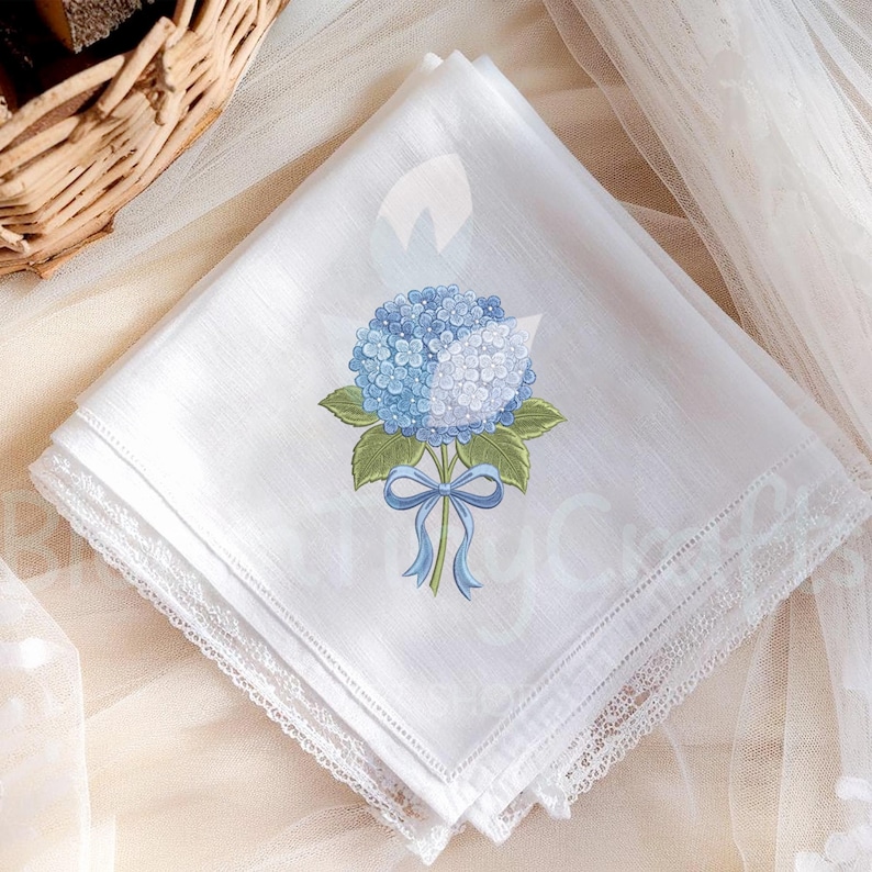 May include: White handkerchief with a blue hydrangea floral design. The embroidered flower has blue petals, green leaves, and a blue ribbon. The edges are trimmed with delicate white lace, creating an elegant and feminine accessory.