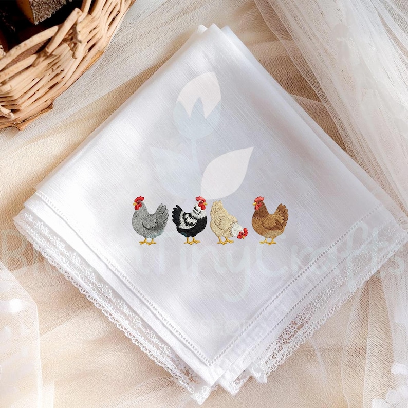 May include: White handkerchief with embroidered chickens in various colors. The handkerchief has a delicate lace trim around the edges. The chickens are gray, black and white, cream, and brown with red combs.