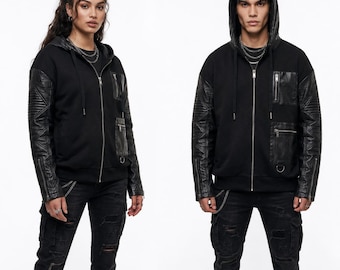 May include: A black zip-up hoodie featuring long sleeves with quilted faux leather panels, a drawstring hood, and multiple zippered pockets on the front. The garment includes silver-toned hardware, ribbed cuffs, and a structured design with a smooth fabric body.
