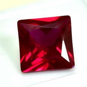 以下が含まれることがあります： 深紅色のスクエアカット、ファセット宝石。 宝石はシャープなエッジと研磨された表面を持ち、光を反射して鮮やかな輝きを生み出します。 この宝石は、ジュエリーによく使用されるルビーである可能性があります。