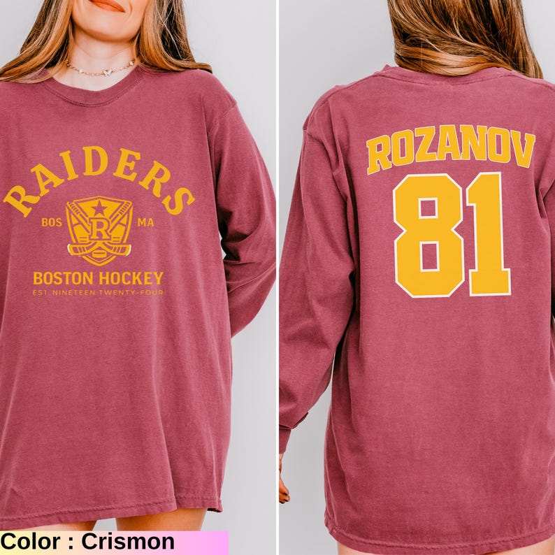 May include: Crimson long-sleeve shirt with "RAIDERS" and "BOSTON HOCKEY" text in gold. The back features "ROZANOV" and the number "81" in gold. The shirt is a comfortable fit.