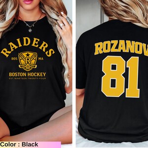 May include: Black t-shirt with "RAIDERS" and "BOSTON HOCKEY" in gold lettering. The front features a hockey-themed logo. The back displays "ROZANOV" and the number "81" in gold. A sports-themed apparel item.