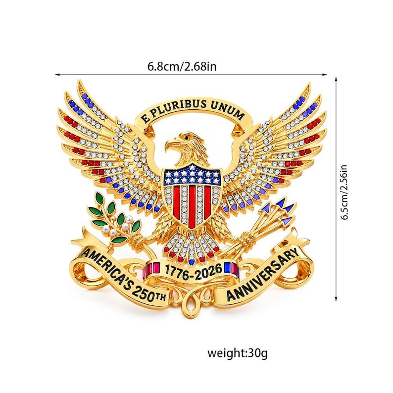 Pu&ograve; includere: Un emblema a forma di aquila in metallo dorato con accenti in smalto rosso, bianco e blu e strass trasparenti. Riporta il testo E PLURIBUS UNUM e AMERICA'S 250TH ANNIVERSARY 1776-2026. Misura 6,8 cm per 6,5 cm e pesa 30 grammi.