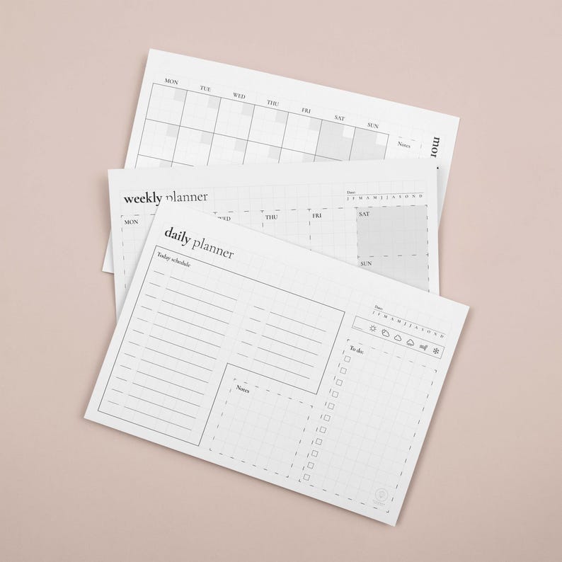 Puede incluir: Una pila de planificadores de papel blanco con dise&ntilde;o mensual, semanal y diario. El planificador diario incluye secciones para un horario, notas y una lista de tareas. El planificador semanal tiene un dise&ntilde;o de cuadr&iacute;cula. El planificador mensual es un calendario.