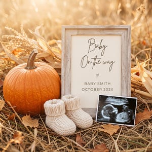 May include: A light wood frame containing a sign that reads Baby On the way, BABY SMITH, OCTOBER 202X, with a small heart icon. Next to the frame is an orange pumpkin, a pair of cream-colored knit baby booties, and a black and white ultrasound scan.