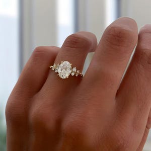 Oval solitaire ring with nature inspired side stones.