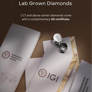 May include: White IGI certificates for lab grown diamonds with the text IGI Certificate For Lab Grown Diamonds and 1 CT and above center diamonds come with a complimentary IGI certificate. A silver jeweler's loupe rests on the documents.