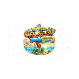 May include: A rectangular sticker featuring a wooden signpost with the text I TOOK A WRONG TURN AT CABOOLTURE and a smaller sign pointing to PARADISE/BRIBIE. The scene includes a blue arrow, tropical beach, palm trees, and ocean at sunset.