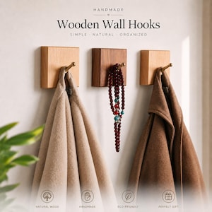 May include: Three square wooden wall hooks with brass-toned pegs mounted on a wall. The text reads: HANDMADE, Wooden Wall Hooks, SIMPLE, NATURAL, ORGANIZED. A beige towel, a beaded necklace, and a brown coat hang from the individual hooks.