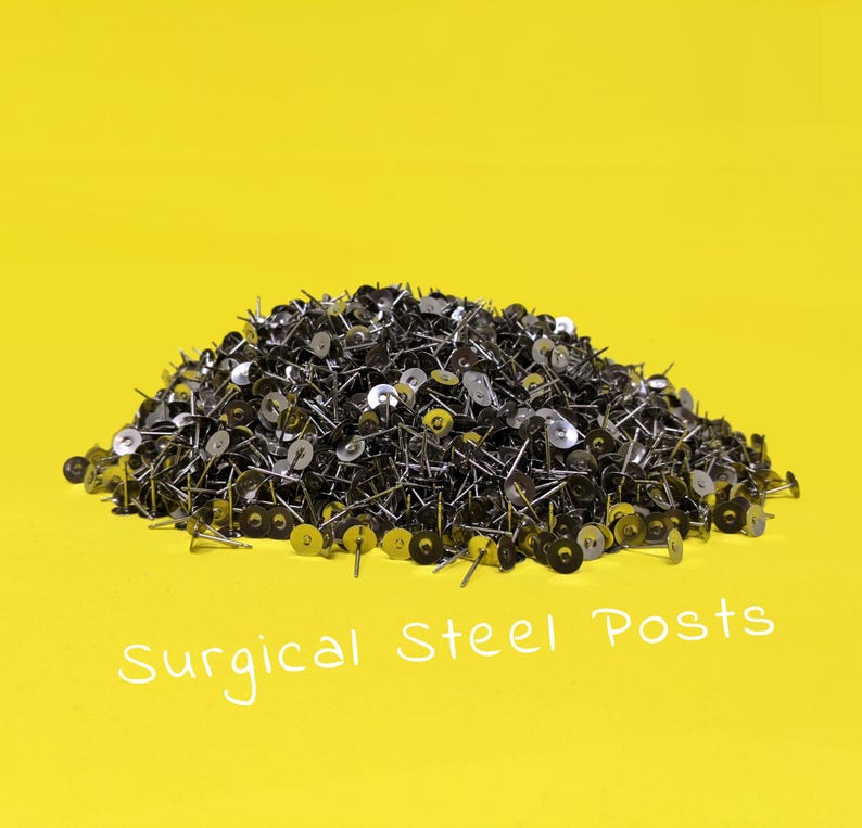 May include: A large pile of silver surgical steel earring posts on a yellow background. The text "Surgical Steel Posts" is written in white below the pile of posts.