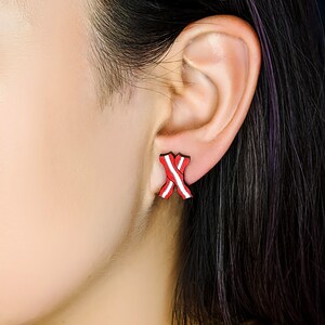 May include: Red and white striped ribbon earrings. The earrings are small and delicate, and they are a great way to add a touch of color to any outfit.