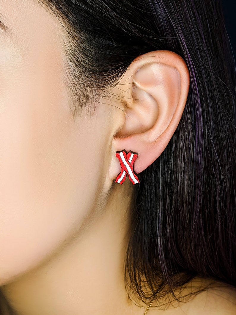 May include: Red and white striped ribbon earrings. The earrings are small and delicate, and they are a great way to add a touch of color to any outfit.
