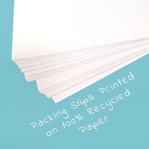 May include: A stack of white packing slips printed on 100% recycled paper. The slips are fanned out, revealing the individual sheets. The background is a solid light blue.