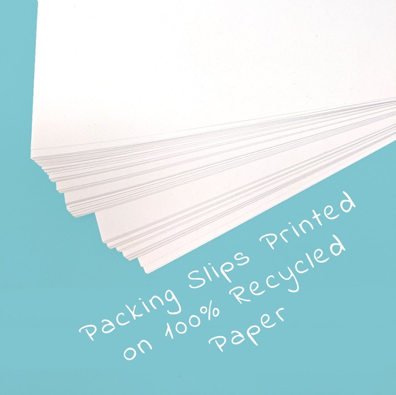 May include: A stack of white packing slips printed on 100% recycled paper. The slips are fanned out, revealing the individual sheets. The background is a solid light blue.