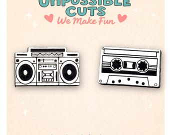 May include: Black and white illustrated boombox and cassette tape pins. The pins are outlined in black and have a retro design. The text "UnPossible Cuts We Make Fun" is at the top, with "handmade in the usa" at the bottom.