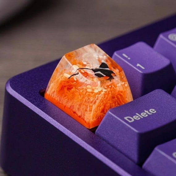 A hand-poured resin stingray gliding through a miniature coral reef scene, sitting right on your mechanical keyboard — tiny aquarium energy for your desk.