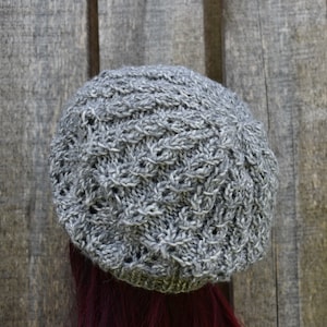 以下が含まれることがあります： 黒い持ち手と「But First, Coffee」のテキストが太字の黒でプリントされた白いセラミックマグ。 マグカップは白い表面に置かれ、そのクリーンなデザインを示しています。