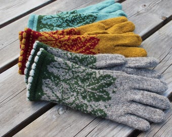 May include: Three pairs of knit gloves featuring intricate patterns. The top pair is light blue with dark green designs, the middle pair is mustard yellow with red patterns, and the bottom pair is heather gray with dark green leaf motifs.