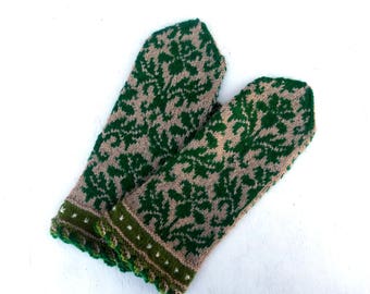 May include: A pair of green and brown knitted mittens with a floral pattern. The mittens have a crocheted edge.