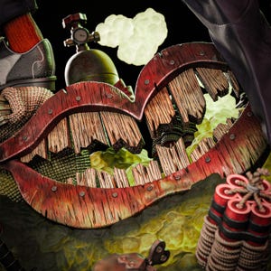 May include: A surreal, artistic rendering featuring a large, wooden mouth with red trim and visible wooden planks. The mouth is surrounded by a green and yellow background, with a dynamite bundle and a metal tank visible. The overall theme is a blend of fantasy and industrial elements.
