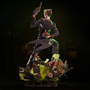 May include: A detailed statue of the Joker, a DC Comics villain, in a dynamic pose. He wears a purple suit with an orange undershirt, holding a gun and a red bomb. The base features a chaotic scene with various props and a green, toxic-looking substance.