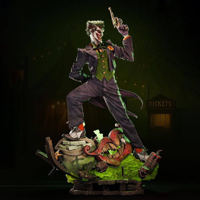 May include: A detailed statue of the Joker, a DC Comics villain, holding a gun. The figure is dressed in a purple suit, green vest, and orange-trimmed shirt. The statue stands on a base with a grinning mouth, money bags, and a sign that says "TICKETS."