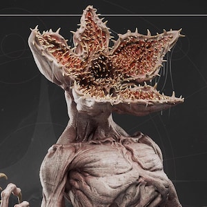 May include: A detailed, three-dimensional rendering of a Demogorgon, a creature with a flower-like head filled with sharp teeth and a humanoid body. The color palette is primarily muted, with shades of gray, brown, and red.