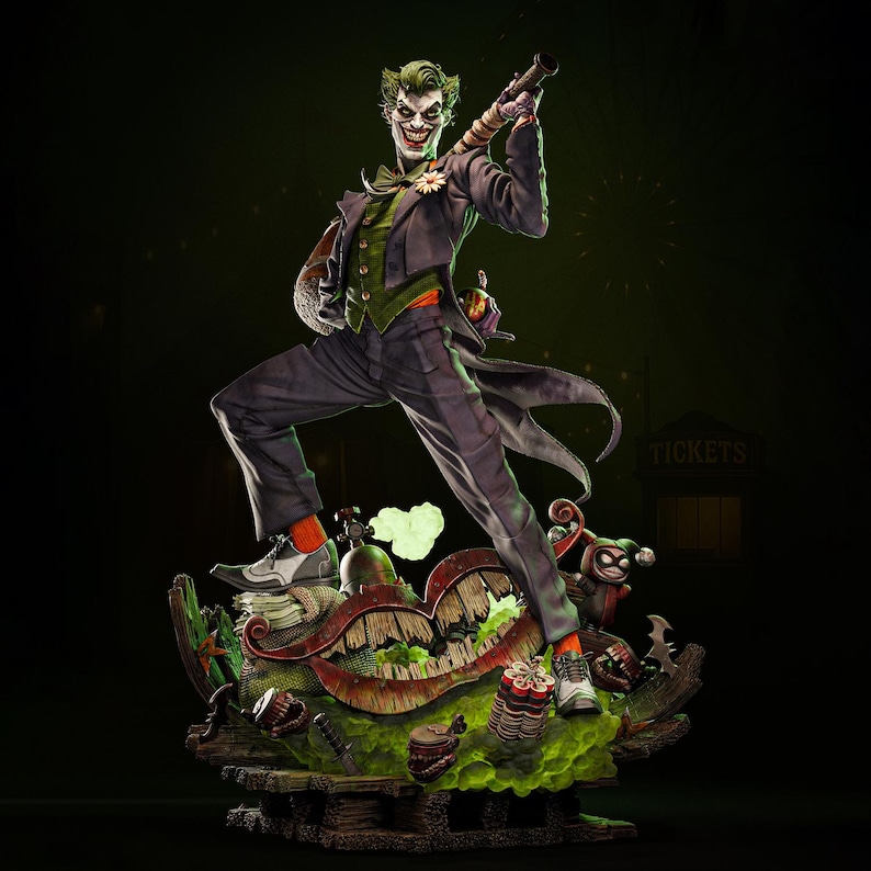 May include: A detailed statue of the Joker, a DC Comics villain, in a dynamic pose. He wears a purple suit, green vest, and orange socks. The base features a chaotic, colorful design with a grinning mouth and other thematic elements.