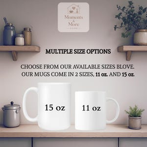 以下が含まれることがあります： 木製の棚に、それぞれ「15 oz」と「11 oz」とラベルされた2つの白いセラミックマグカップが展示されています。「MULTIPLE SIZE OPTIONS」というテキストとその他のテキストがマグカップの上にあります。画像には装飾要素も含まれています。