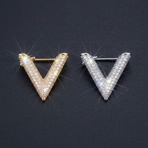 Peut inclure: Ensemble de trois mugs en céramique avec une finition mate et mouchetée. Les tasses sont de couleur crème, gris clair et gris foncé. Chaque mug a un design simple et minimaliste.