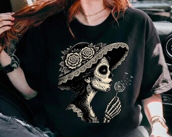 La Catrina Blowing Wishes Dandelion Comfort kleuren T-shirt, Sugar Skull Art Gift, grafische T-shirt Day of the Dead Lover, Gothic Floral T-shirt
