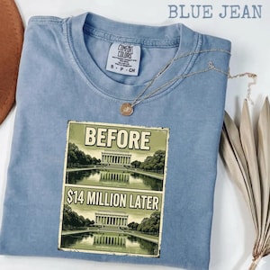 Könnte beinhalten: Ein blaues T-Shirt in Jeansoptik mit einem Grafikdruck des Lincoln Memorials und dem Text BEFORE sowie $14 MILLION LATER. Das Shirt hat einen Rundhalsausschnitt und ein Comfort Colors Markenetikett am Innenkragen. Eine dünne goldene Kette liegt auf dem Stoff.
