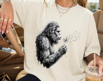 Grappige Bigfoot Blowing Wishes comfortkleuren Shirt, vintage Sasquatch-T-shirt, paardebloem grafisch T-shirt, retro Cryptid-shirt, cadeau natuurliefhebber
