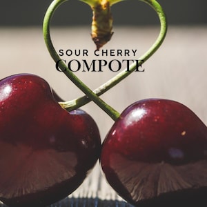 May include: A close-up shot of two deep red cherries, with a green stem arranged in a heart shape. The text "SOUR CHERRY COMPOTE" is displayed in a bold font, suggesting a culinary theme.