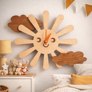 May include: A wooden sun-shaped wall clock with a smiling face and orange clock hands. Two dark brown wooden cloud accents are placed on either side of the sun. The clock is mounted on a white wall, ideal for a nursery or playroom.