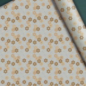 May include: A roll of floral patterned wrapping paper. The design features clusters of brown and tan flowers on a light gray background. The flowers are arranged in a repeating pattern with small dots and lines.