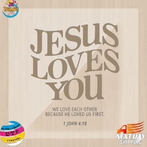May include: A light brown graphic with the text "JESUS LOVES YOU" in a bold, serif font. Below, it reads "WE LOVE EACH OTHER BECAUSE HE LOVED US FIRST. 1 JOHN 4:19". The image includes a "Transfer DTF" logo and a "NEXT DAY SHIPPING" graphic.