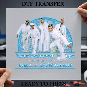 Può includere: Un foglio di trasferimento DTF con una grafica dei Backstreet Boys in abiti bianchi su uno sfondo a globo blu. Il testo recita "DTF TRANSFER", "backstreet boys", "INTO THE MILLENNIUM" e "READY TO PRESS" in un carattere blu in grassetto.