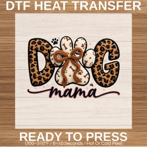 May include: DTF heat transfer design featuring the words "DOG mama" with a paw print design. The letters "D" and "G" have a leopard print pattern. The paw print is white with brown bone accents and a brown bow.