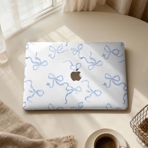 Könnte beinhalten: Ein Set aus drei Keramikbechern mit gesprenkelter, matter Oberfläche. Jeder Becher hat eine andere Farbe: hellblau, creme und grau. Die Becher haben ein schlichtes, modernes Design.