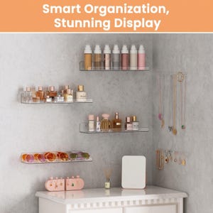 May include: Four clear acrylic wall-mounted shelves holding perfume bottles and sunglasses, with two wall-mounted jewelry racks displaying necklaces and earrings. The text "Smart Organization, Stunning Display" appears at the top of the image.