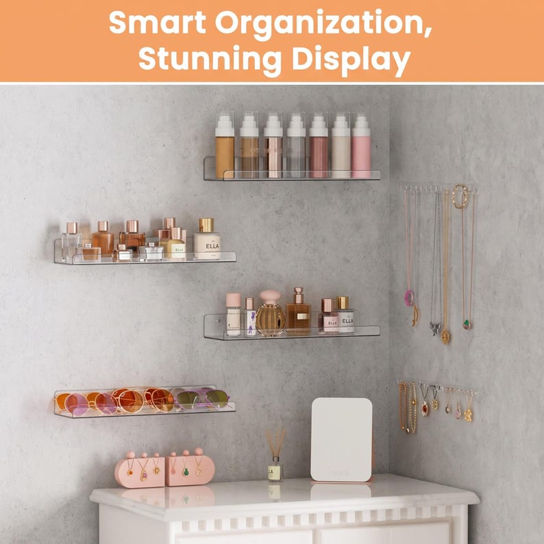 May include: Four clear acrylic wall-mounted shelves holding perfume bottles and sunglasses, with two wall-mounted jewelry racks displaying necklaces and earrings. The text "Smart Organization, Stunning Display" appears at the top of the image.