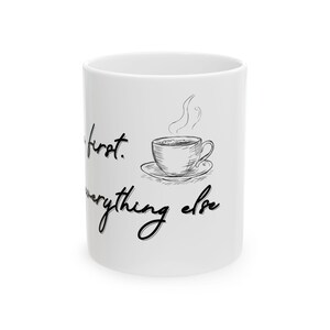 Könnte beinhalten: Weißer Keramik-Kaffeebecher mit dem Text "Coffee first. Everything else" in schwarzer Schrift. Auf dem Becher befindet sich auch eine Skizze einer Kaffeetasse mit aufsteigendem Dampf. Der Becher ist zylindrisch und hat einen Henkel.