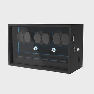 May include: A black watch winder with a glass door, featuring multiple watch holders. The interior has a blue light. The winder has a key and a tassel.