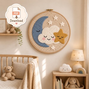 Könnte beinhalten: Ein kreisförmiger Wandbehang mit einem gehäkelten Design aus einer blauen Mondsichel, einer weißen Wolke mit lächelndem Gesicht und rosa Wangen sowie einem gelben Stern mit lächelndem Gesicht, alles auf beigem Grund in einem Holzrahmen.